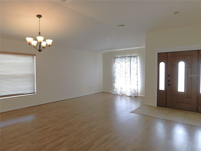 foyer entrance with a chandelier, baseboards, light wood-type flooring, and visible vents