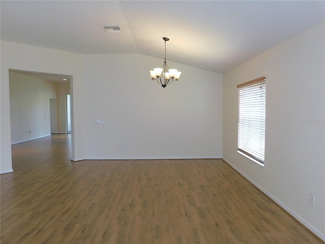 unfurnished room with lofted ceiling, wood finished floors, visible vents, a chandelier, and baseboards