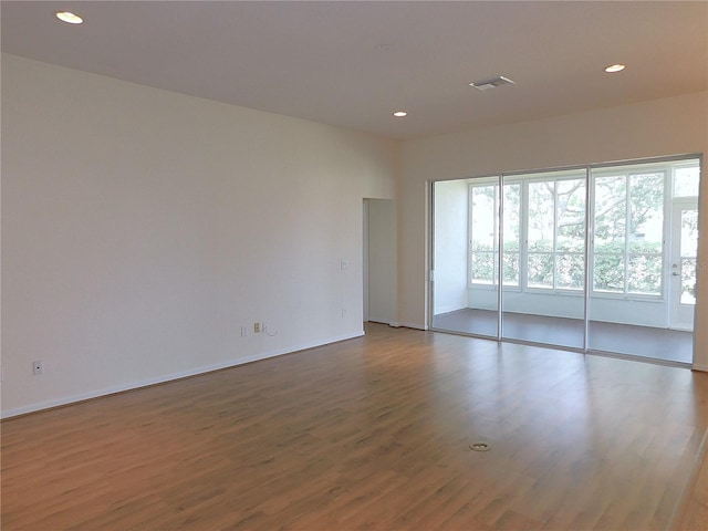 empty room with recessed lighting, baseboards, and wood finished floors