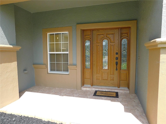 view of exterior entry with stucco siding