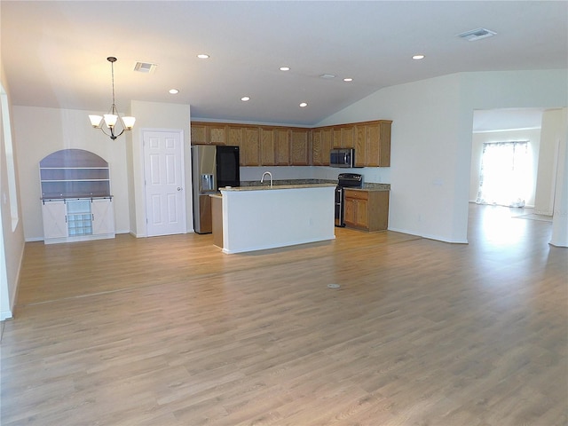 kitchen featuring an inviting chandelier, appliances with stainless steel finishes, brown cabinets, and open floor plan