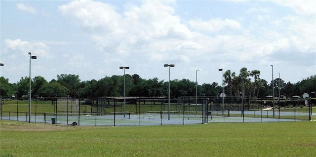 view of sport court featuring a yard and fence