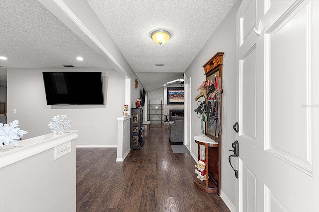 corridor with dark hardwood / wood-style flooring and a textured ceiling