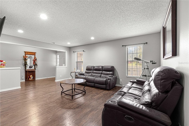 living room featuring dark hardwood / wood-style flooring and a textured ceiling