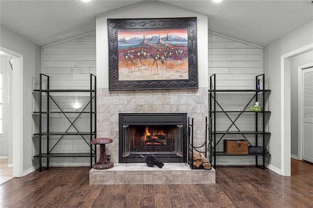 room details with wood walls, a fireplace, a textured ceiling, and hardwood / wood-style flooring