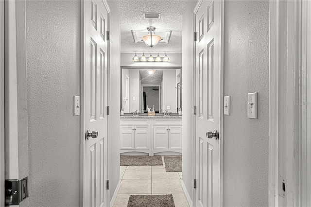 bathroom with tile patterned floors, vanity, and a textured ceiling