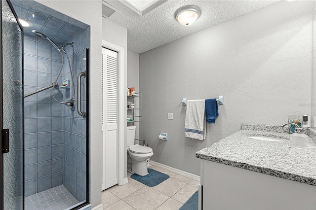 bathroom featuring a tile shower, tile patterned floors, a textured ceiling, toilet, and vanity