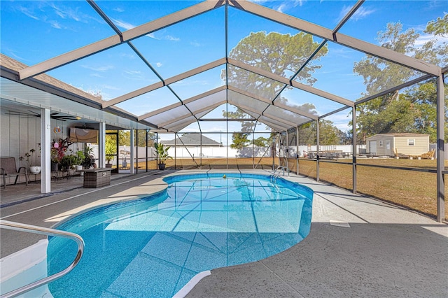 view of pool featuring a patio area, ceiling fan, a yard, and glass enclosure