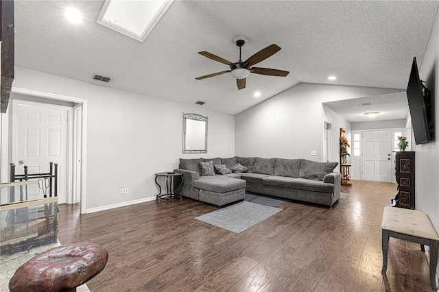 living room featuring a textured ceiling, dark hardwood / wood-style flooring, lofted ceiling with skylight, and ceiling fan