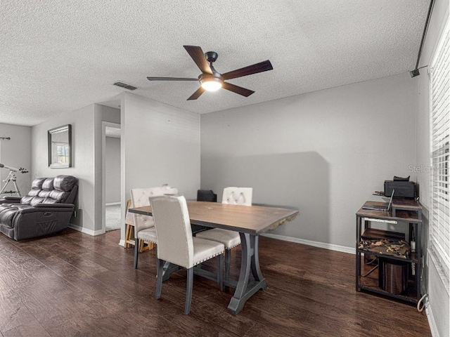 dining space featuring a textured ceiling, ceiling fan, and dark wood-type flooring