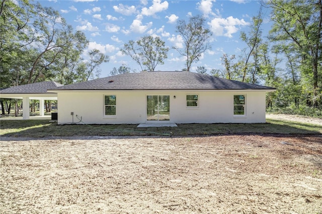 back of property featuring a carport and central air condition unit