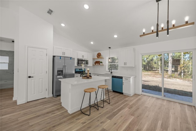 kitchen with white cabinetry, a center island, hanging light fixtures, high vaulted ceiling, and appliances with stainless steel finishes