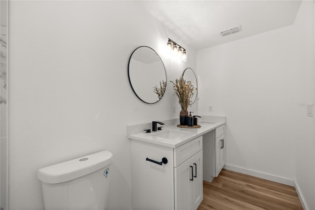 bathroom with hardwood / wood-style flooring, vanity, and toilet