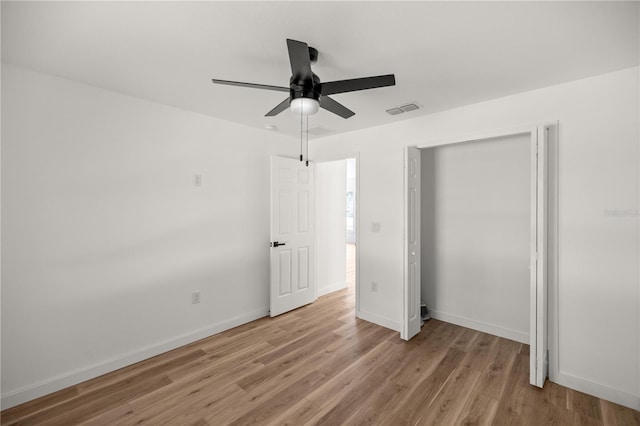 unfurnished bedroom with a closet, light hardwood / wood-style flooring, and ceiling fan