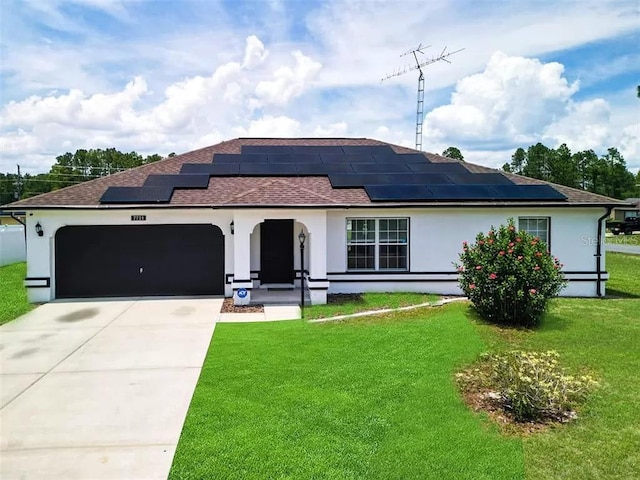 view of front of home with solar panels, a garage, and a front lawn