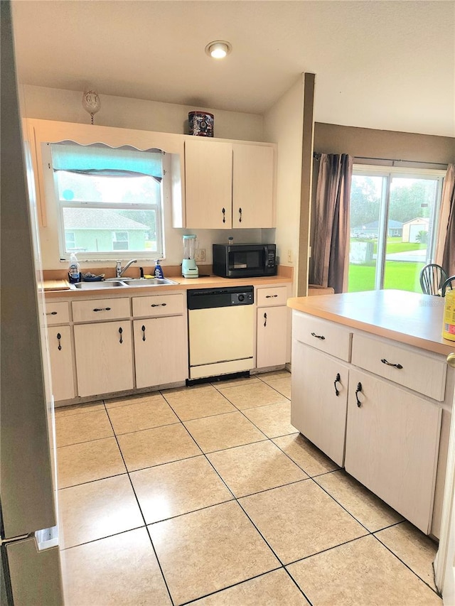 kitchen featuring light tile patterned floors, white dishwasher, plenty of natural light, and sink