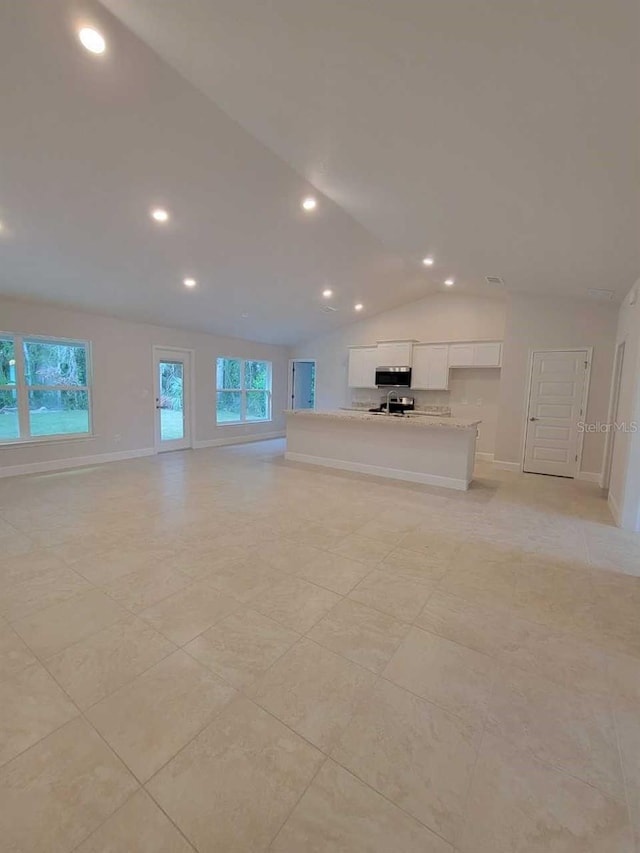 unfurnished living room with light tile patterned flooring and lofted ceiling