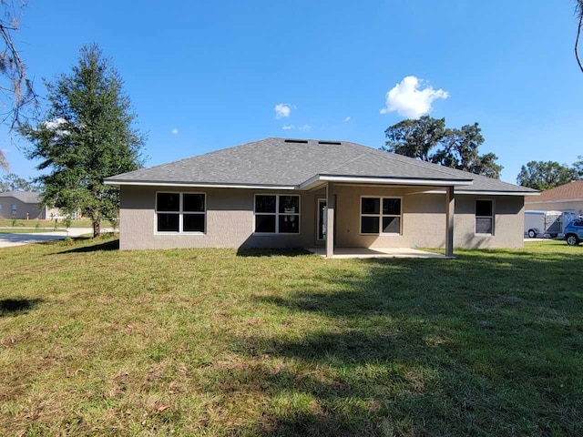 rear view of property featuring a patio area and a yard