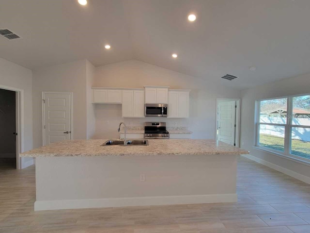 kitchen with stainless steel appliances, white cabinetry, a kitchen island with sink, and sink