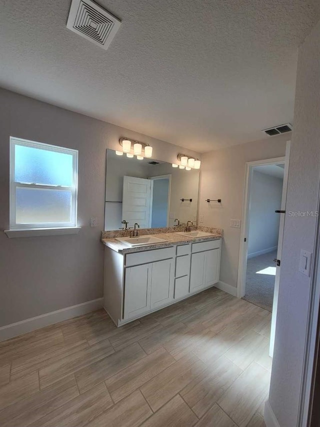 bathroom featuring vanity, hardwood / wood-style floors, and a textured ceiling