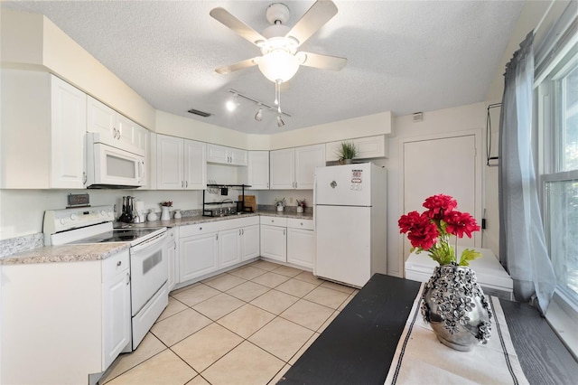 kitchen featuring a textured ceiling, white appliances, ceiling fan, light tile patterned floors, and white cabinetry