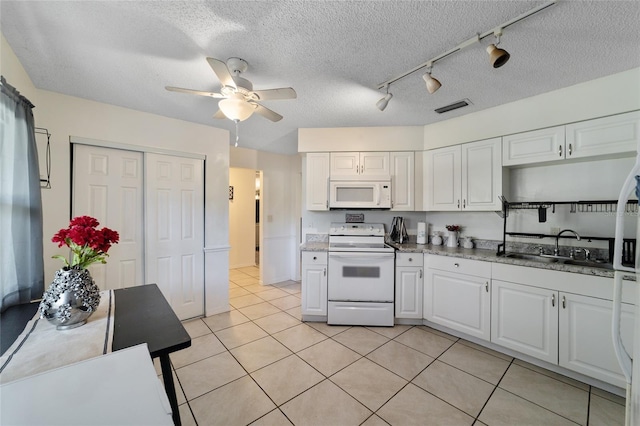 kitchen featuring ceiling fan, white cabinets, a textured ceiling, white appliances, and light tile patterned floors