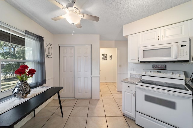 kitchen with white appliances, ceiling fan, light tile patterned floors, a textured ceiling, and white cabinetry