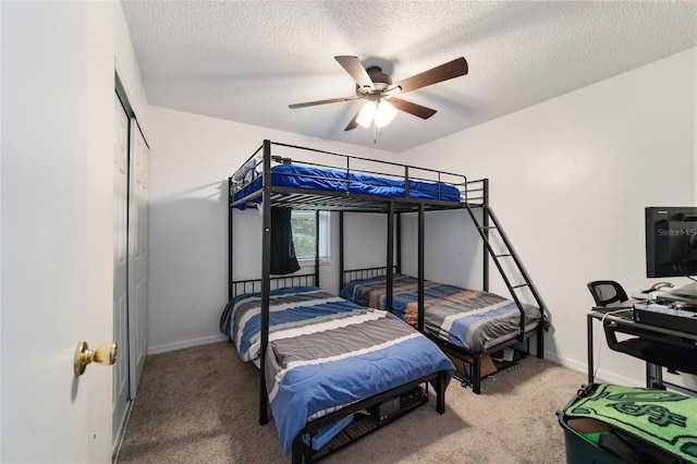 carpeted bedroom with ceiling fan, a textured ceiling, and a closet