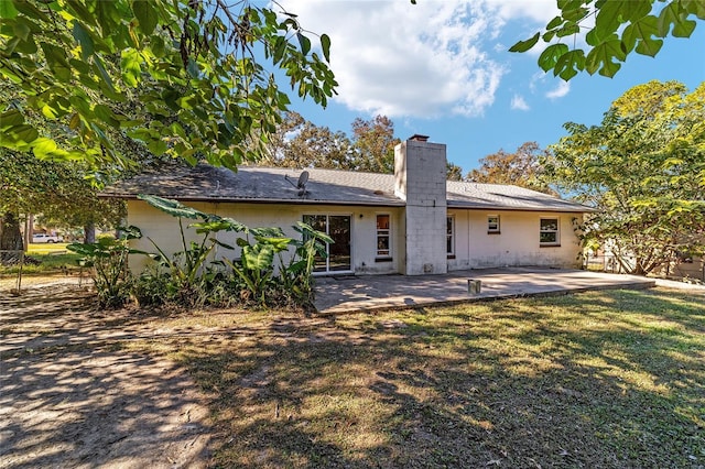 back of house featuring a lawn and a patio area