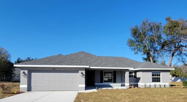 single story home with a garage and a front lawn