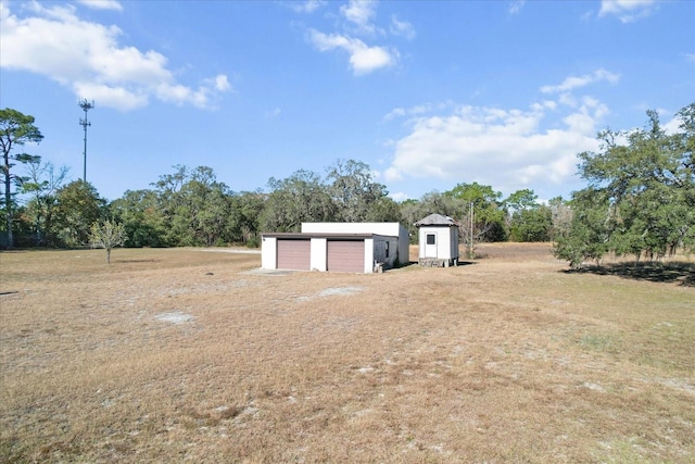 view of yard with a garage, a storage shed, and an outdoor structure