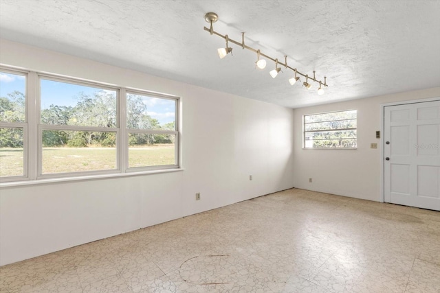 unfurnished room with a textured ceiling and light floors