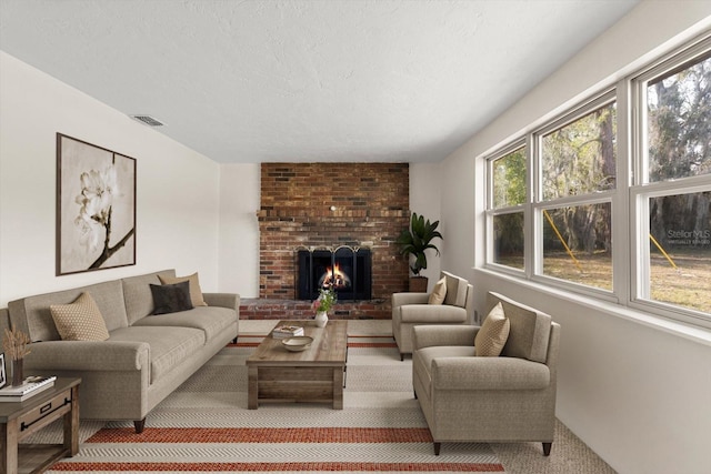 living room with a fireplace, visible vents, a textured ceiling, and light colored carpet