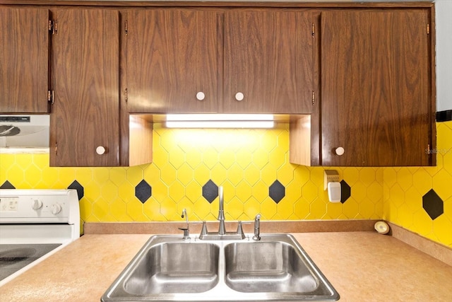 kitchen with range hood, white range with electric stovetop, light countertops, and backsplash