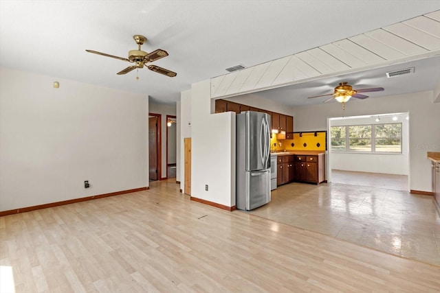 unfurnished living room with baseboards, visible vents, and light wood-style floors