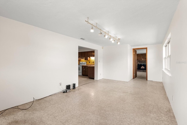 unfurnished room featuring a brick fireplace and visible vents