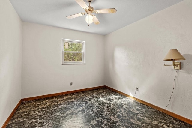 empty room featuring a ceiling fan and baseboards