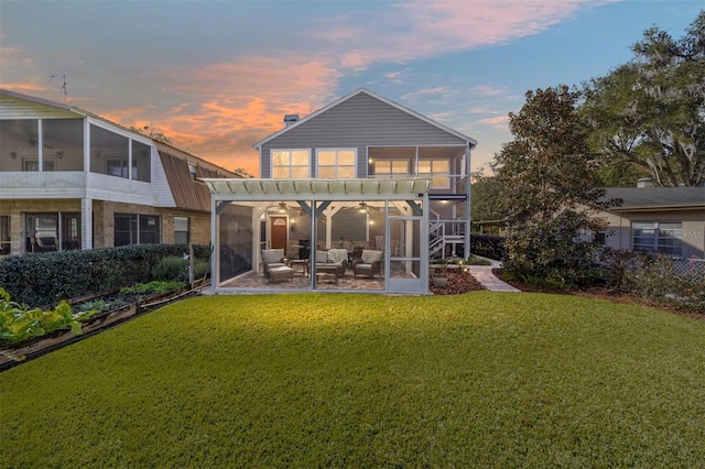 back house at dusk featuring a lawn, a pergola, outdoor lounge area, and a patio