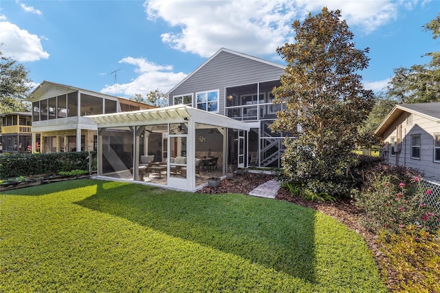 rear view of house with a lawn and a sunroom