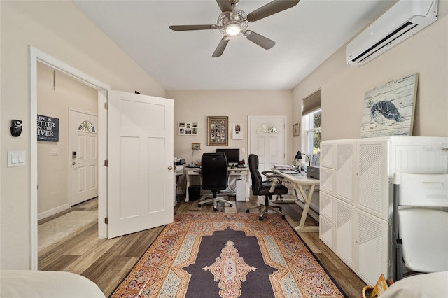 home office featuring hardwood / wood-style floors, a wall unit AC, and ceiling fan