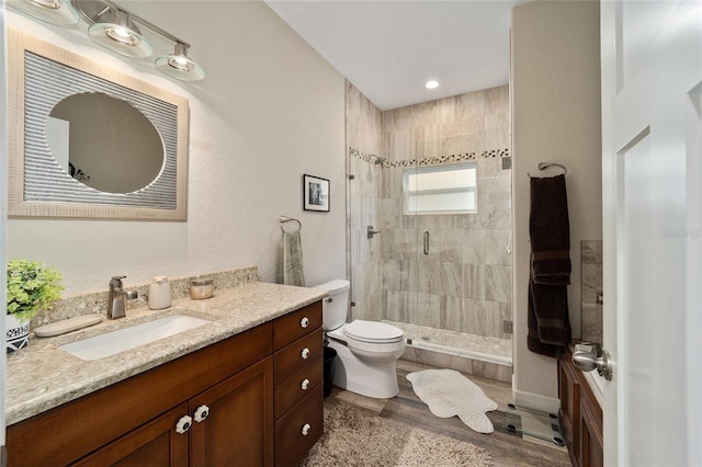 bathroom with hardwood / wood-style flooring, vanity, toilet, and an enclosed shower