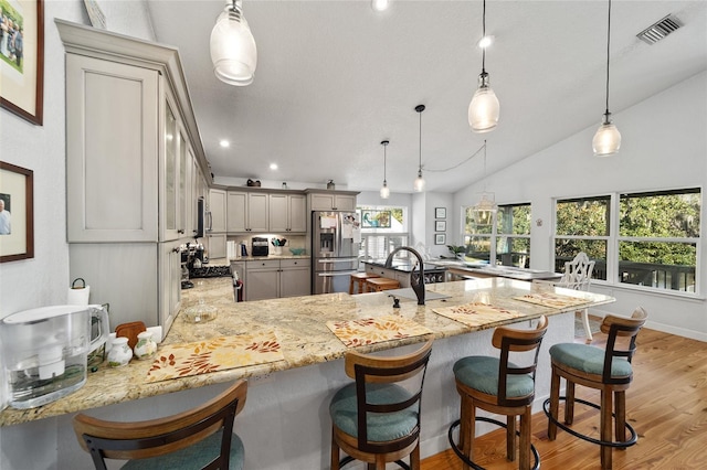 kitchen featuring hanging light fixtures, stainless steel refrigerator with ice dispenser, gray cabinets, and plenty of natural light