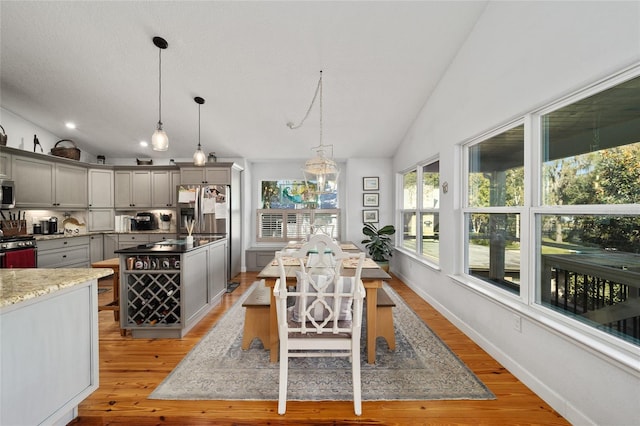 dining room featuring light hardwood / wood-style flooring and vaulted ceiling