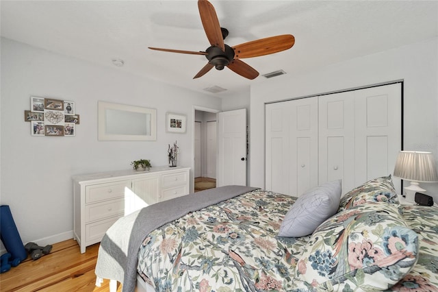 bedroom with a closet, light hardwood / wood-style floors, and ceiling fan