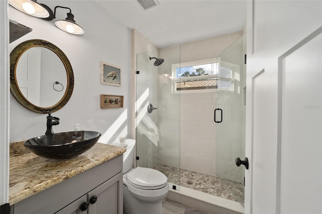 bathroom featuring vanity, toilet, and walk in shower