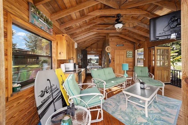 sunroom with vaulted ceiling with beams, ceiling fan, and wood ceiling