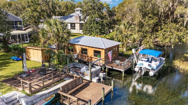 dock area featuring a lawn and a deck with water view