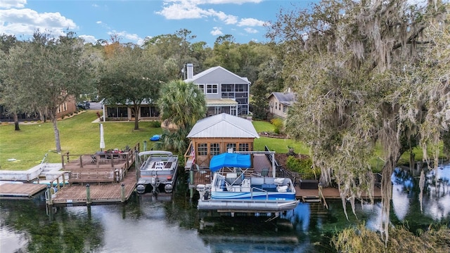 view of dock with a lawn and a water view