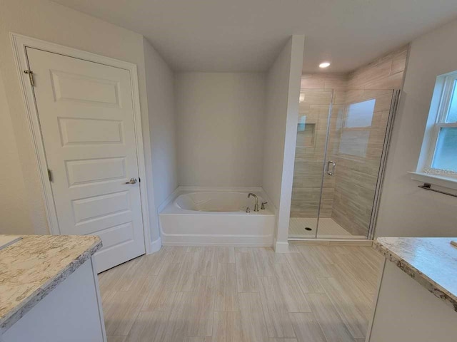 bathroom with a bath, recessed lighting, vanity, and a stall shower