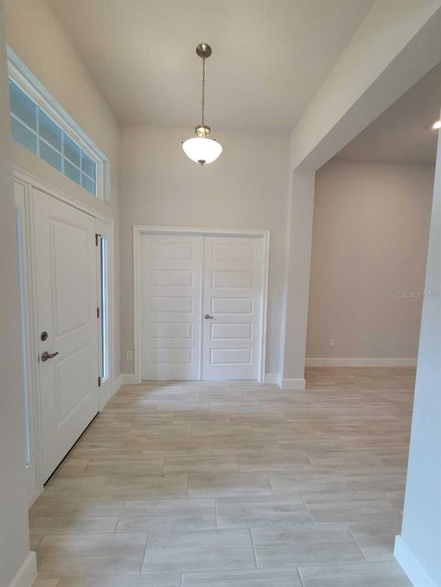 foyer featuring baseboards and light wood finished floors